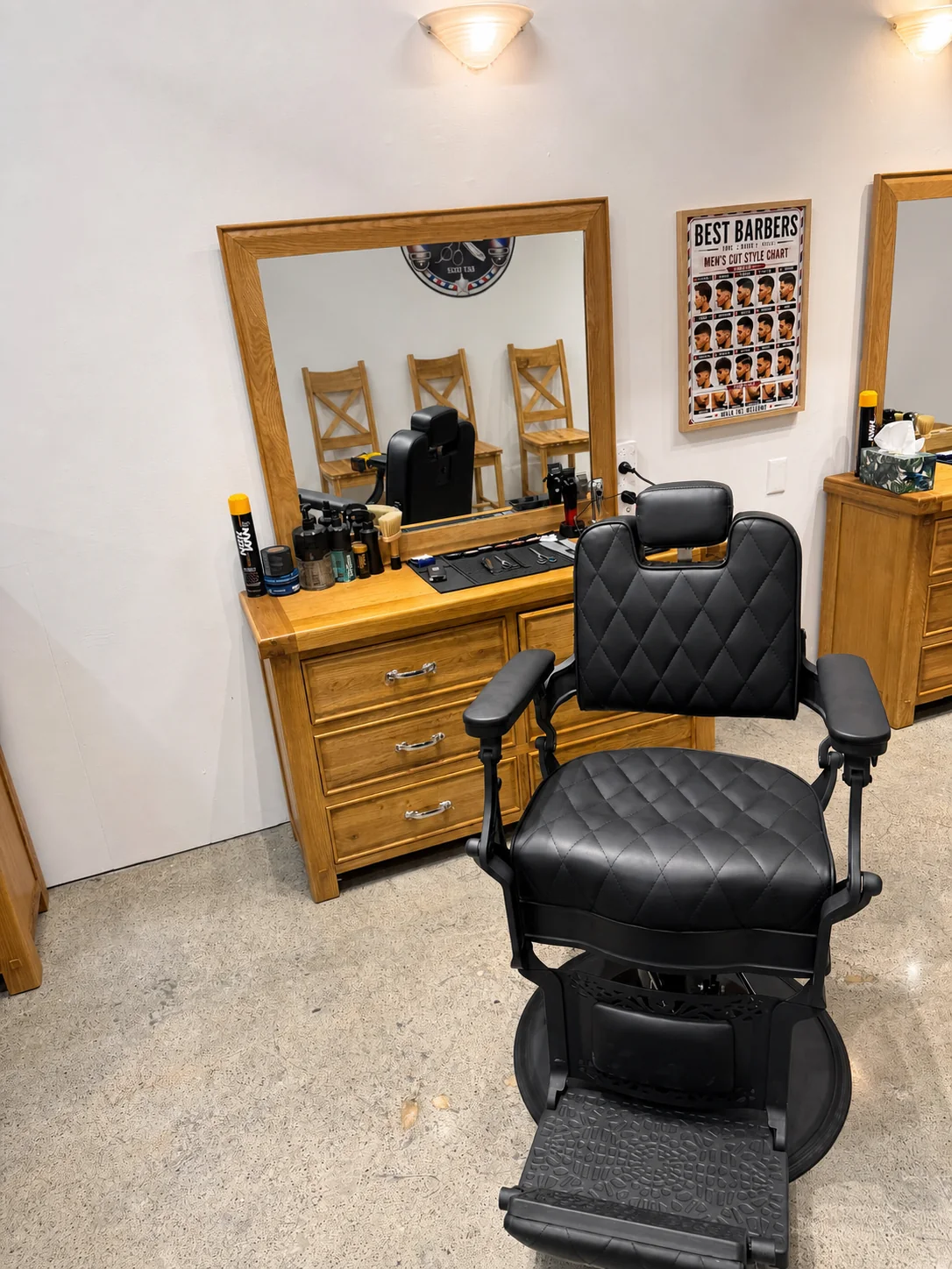 Clean black barber chair and timber barber station inside Best Barbers Napier